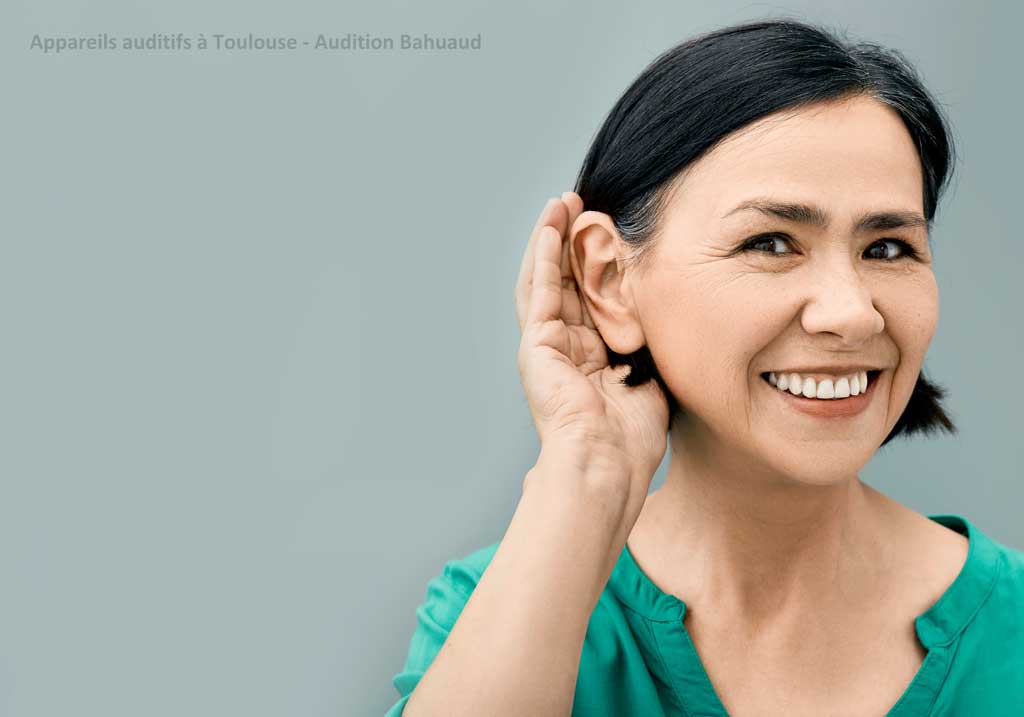femme brune portant une main à son oreille pour écouter