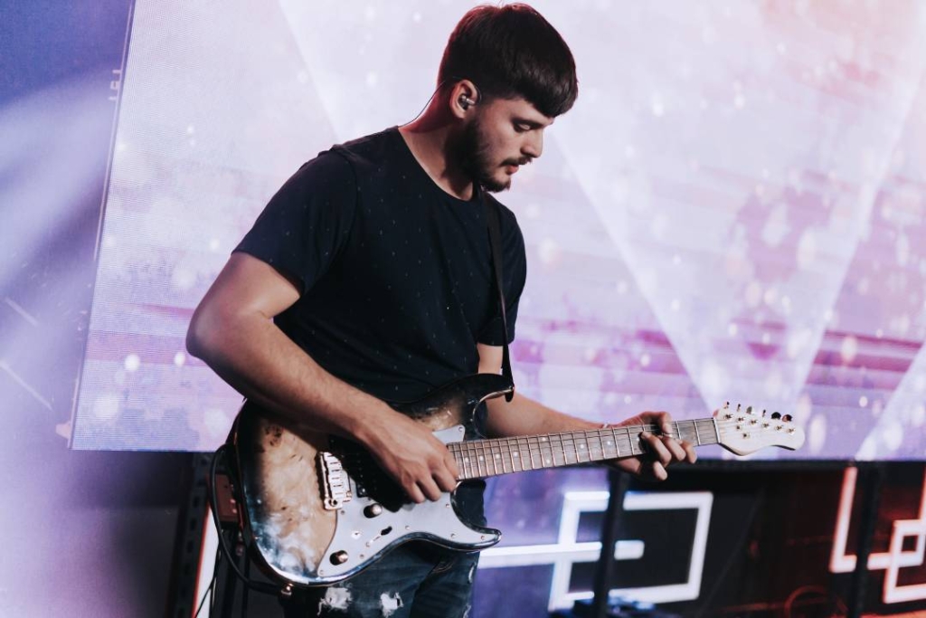 Guitariste sur scène portant une protection auditive adaptée pour musiciens