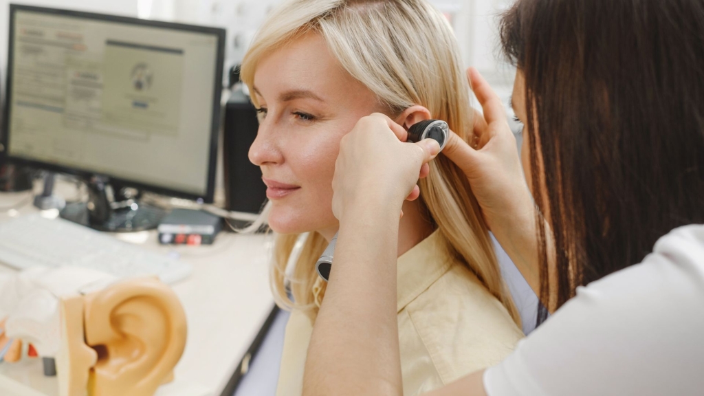 Audioprothésiste d’Audition Bahuaud ajustant les appareils auditifs d’un patient lors d’un rendez-vous de suivi à Toulouse.
