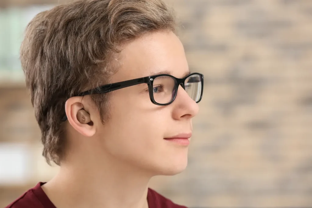Appareil auditif intra-auriculaire porté par un jeune homme.