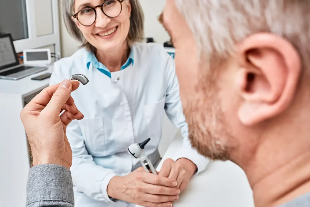 Un audioprothésiste conseille un patient lors du choix de son appareil auditif.